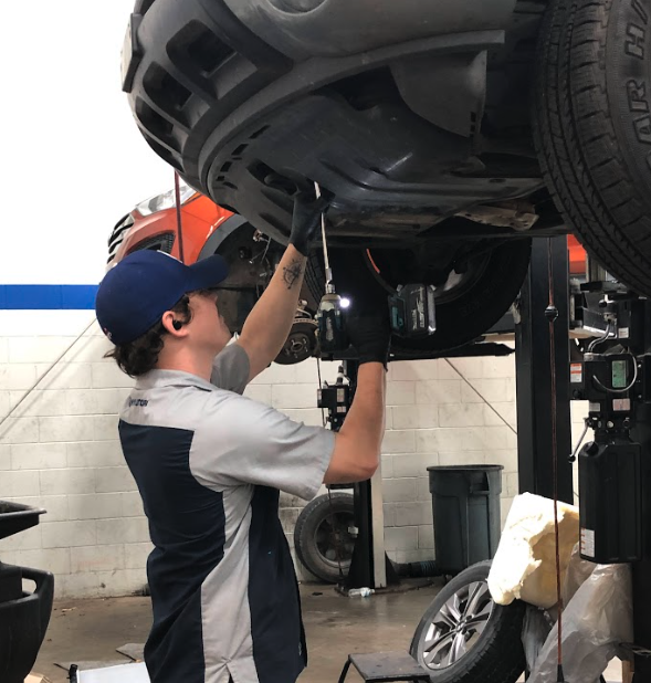 Hyundai technician working underneath a vehicle at Crain Hyundai of Fayetteville